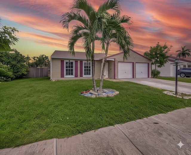 5279 Canal Cir W, Lake Worth, FL 33467 - view of front of property with fence, an attached garage, concrete driveway, and a front yard