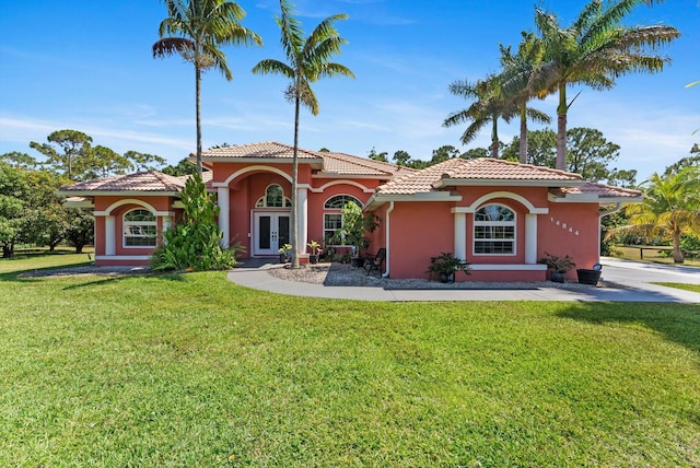 14844 Tangerine Blvd, The Acreage, FL 33470 - mediterranean / spanish home with french doors, stucco siding, a front lawn, and a tile roof