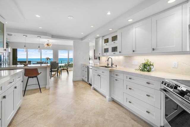 4001 N Ocean Blvd Unit 1108, Boca Raton, FL 33431 - kitchen featuring a sink, stainless steel appliances, decorative backsplash, white cabinets, and recessed lighting