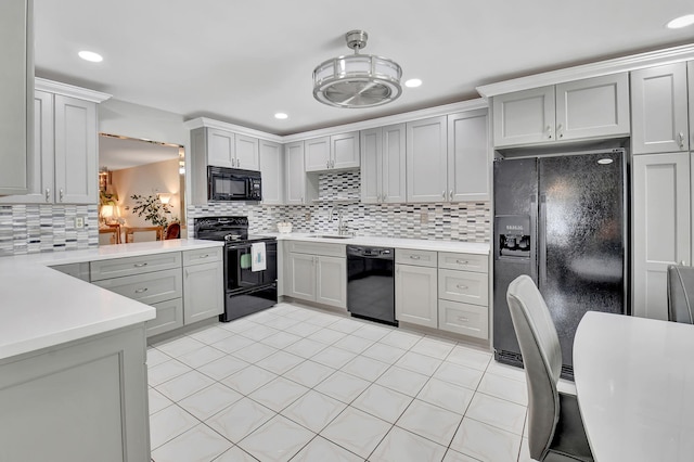 5154 Privet Pl Unit A, Delray Beach, FL 33484 - kitchen with black appliances, tasteful backsplash, light countertops, recessed lighting, and gray cabinets