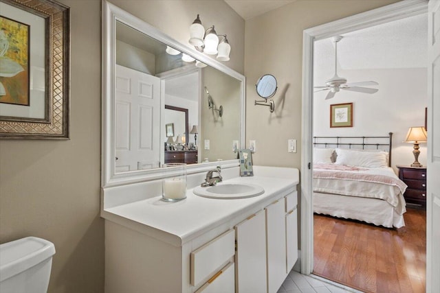 bathroom with vanity, a ceiling fan, ensuite bath, and toilet