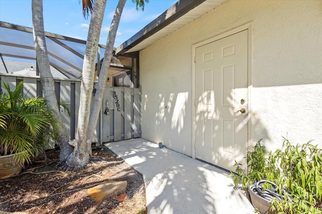 entrance to property featuring a gate and stucco siding