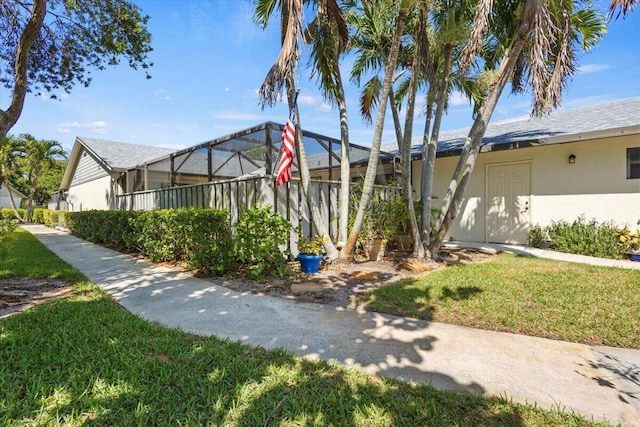 view of side of home featuring a lawn, a lanai, and stucco siding