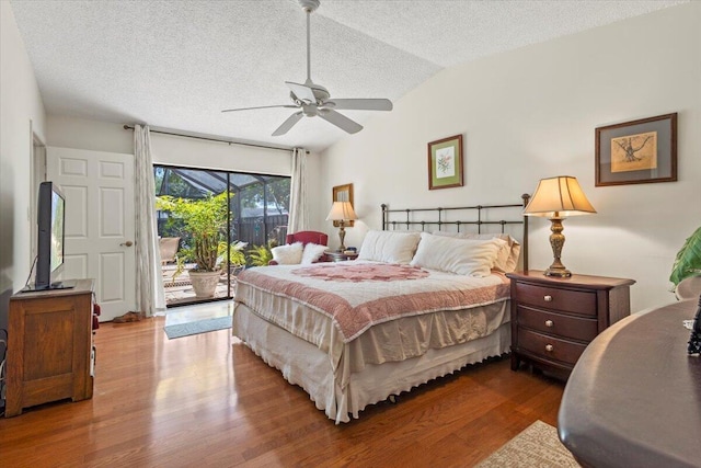 bedroom with ceiling fan, a textured ceiling, access to exterior, wood finished floors, and lofted ceiling