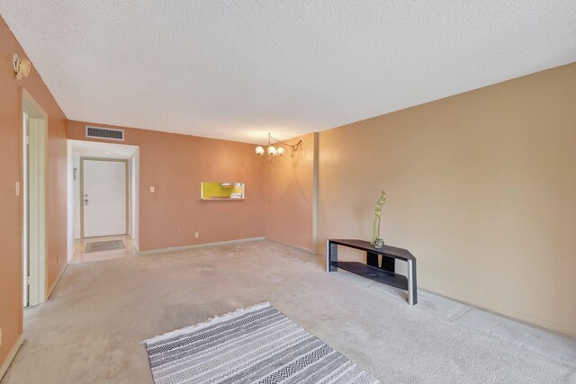 3301 NW 47th Ter Unit 410, Lauderdale Lakes, FL 33319 - unfurnished living room featuring carpet flooring, a notable chandelier, a textured ceiling, visible vents, and baseboards