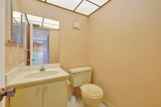 3301 NW 47th Ter Unit 410, Lauderdale Lakes, FL 33319 - half bathroom featuring toilet, baseboards, vanity, and washer / clothes dryer