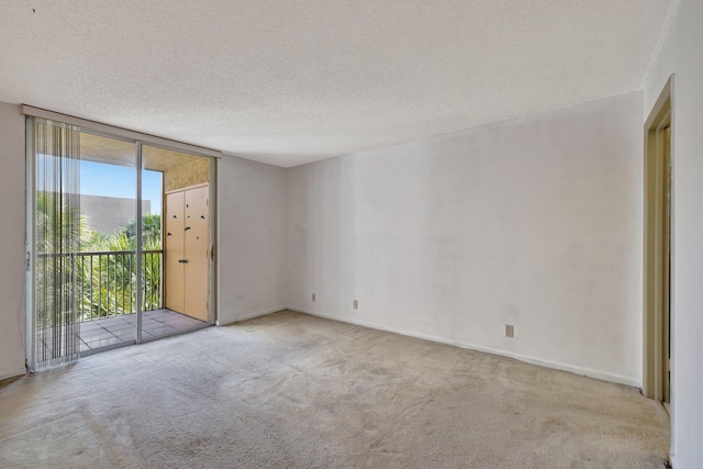 3301 NW 47th Ter Unit 410, Lauderdale Lakes, FL 33319 - carpeted empty room with a textured ceiling, baseboards, and floor to ceiling windows