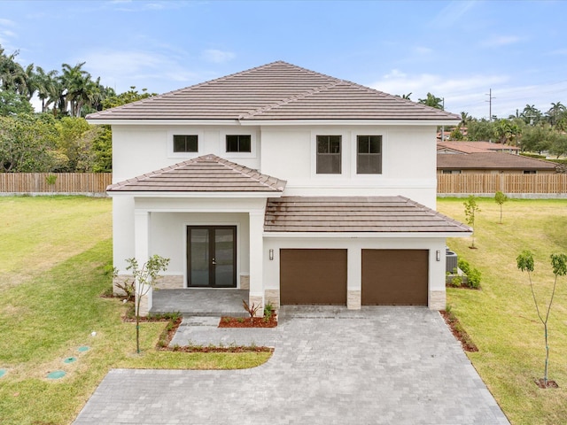 view of front of house featuring fence, an attached garage, french doors, driveway, and a front lawn