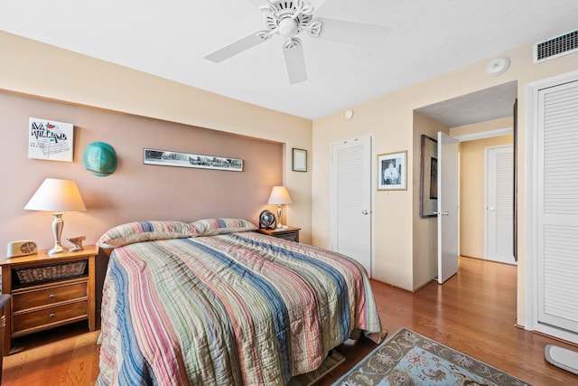 bedroom featuring ceiling fan, visible vents, and wood finished floors