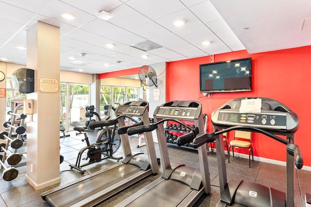workout area with baseboards and a paneled ceiling