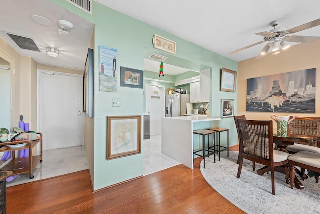 dining room with ceiling fan, visible vents, and light wood-style flooring