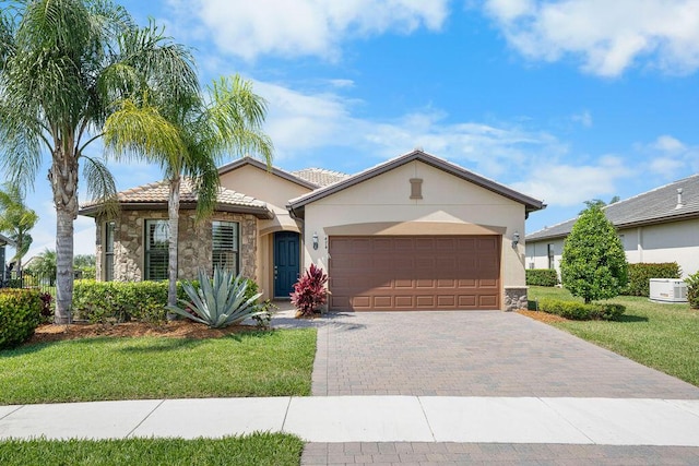 single story home with a garage, a front lawn, stone siding, decorative driveway, and stucco siding