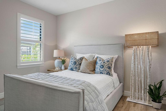 bedroom featuring baseboards and wood finished floors