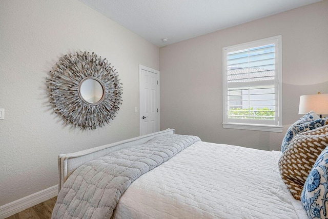 bedroom featuring baseboards and wood finished floors