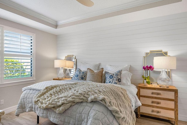 bedroom with crown molding, baseboards, wood walls, and wood finished floors