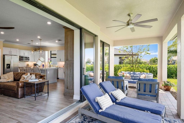 sunroom / solarium featuring crown molding, wood finished floors, and a wealth of natural light