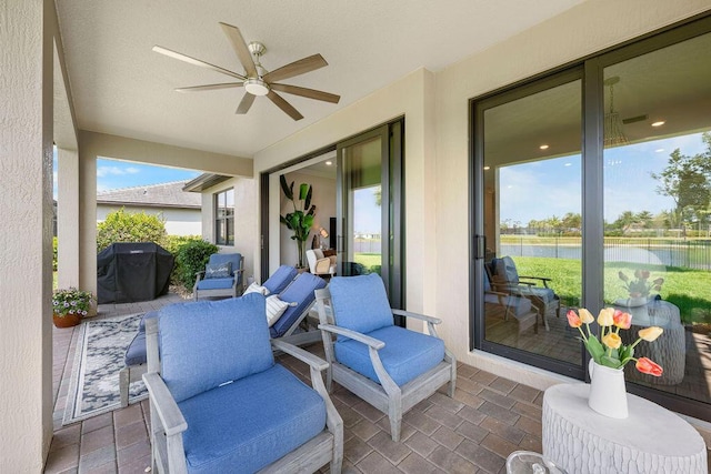 view of patio featuring a water view, ceiling fan, and a grill
