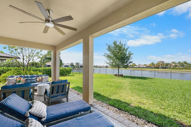 view of patio featuring a water view, ceiling fan, an outdoor hangout area, and a fenced backyard