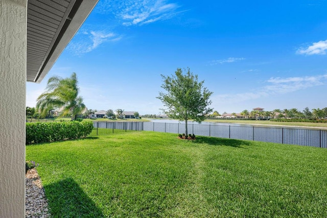 view of yard with a water view and fence