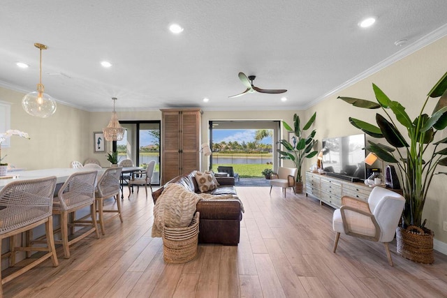 living area featuring recessed lighting, ornamental molding, light wood finished floors, and ceiling fan