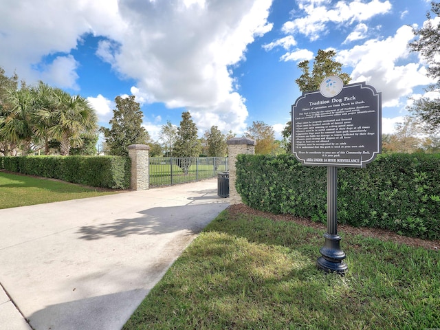 exterior space with concrete driveway, fence, and a gate