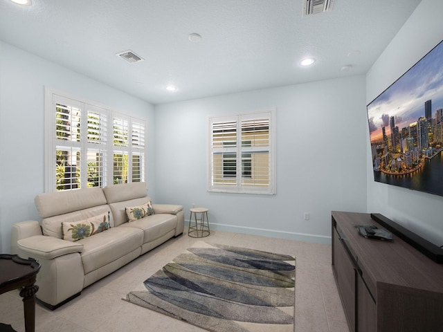 living area featuring light tile patterned floors, baseboards, recessed lighting, and visible vents