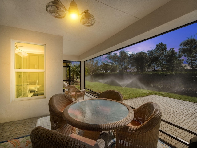 sunroom / solarium featuring brick floor and outdoor dining area