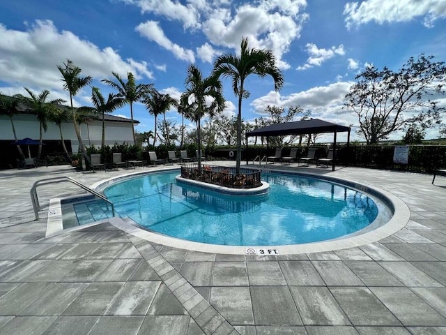 community pool featuring a gazebo, fence, and a patio area