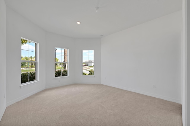 unfurnished room with recessed lighting, baseboards, and light colored carpet
