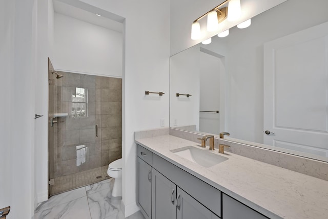 bathroom featuring vanity, toilet, marble finish floor, and a stall shower