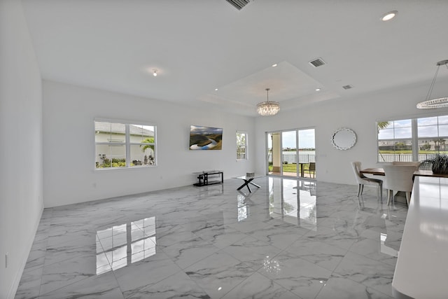 interior space featuring an inviting chandelier, marble finish floor, recessed lighting, a tray ceiling, and visible vents