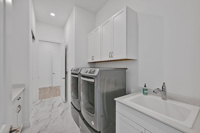 clothes washing area with washing machine and dryer, cabinet space, a sink, marble finish floor, and recessed lighting