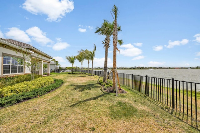 view of yard with a fenced backyard and a water view