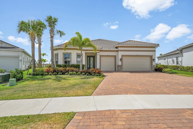 view of front of property with decorative driveway, an attached garage, a front lawn, and stucco siding