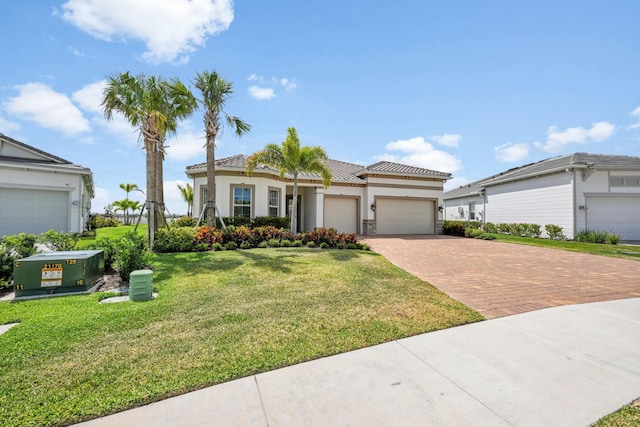 view of front of house with a garage, stucco siding, a front yard, decorative driveway, and a tiled roof