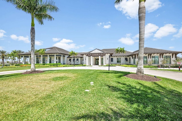 view of front of house featuring curved driveway and a front yard