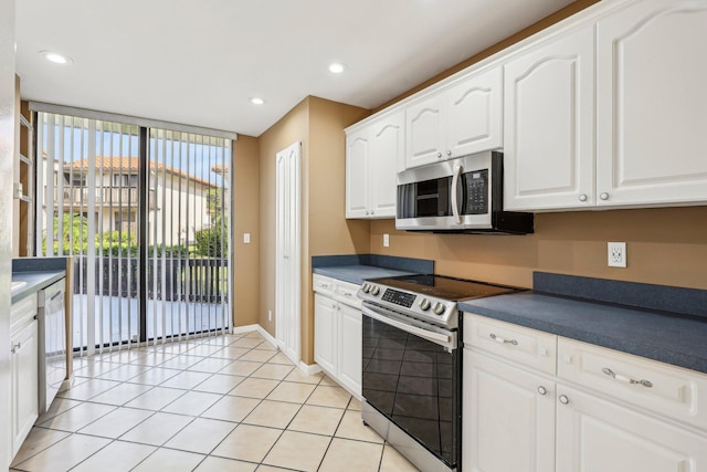 5748 Fox Hollow Dr Unit D, Boca Raton, FL 33486 - kitchen featuring dark countertops, appliances with stainless steel finishes, light tile patterned floors, and white cabinetry