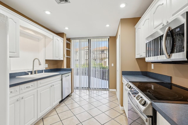 5748 Fox Hollow Dr Unit D, Boca Raton, FL 33486 - kitchen featuring white cabinets, dark countertops, appliances with stainless steel finishes, a sink, and recessed lighting