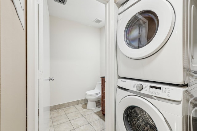 5748 Fox Hollow Dr Unit D, Boca Raton, FL 33486 - laundry room with laundry area, stacked washer and dryer, visible vents, light tile patterned floors, and baseboards