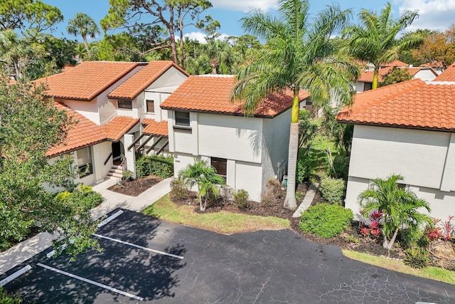 5748 Fox Hollow Dr Unit D, Boca Raton, FL 33486 - view of front facade featuring uncovered parking, stucco siding, and a tile roof