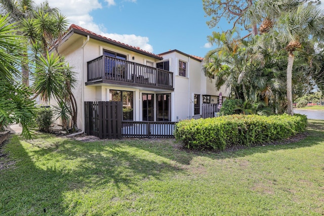 5748 Fox Hollow Dr Unit D, Boca Raton, FL 33486 - rear view of house with a tiled roof, a yard, stucco siding, and a balcony