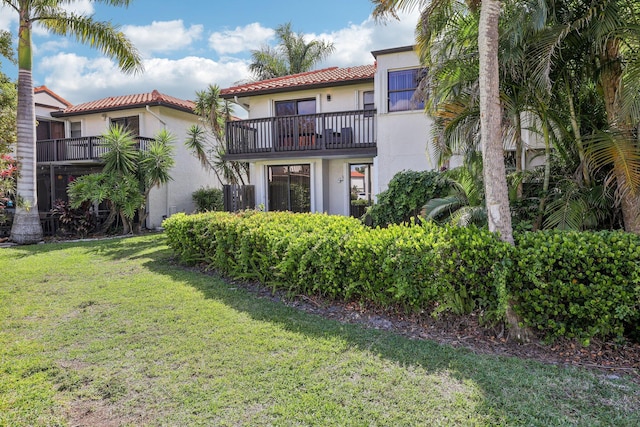 5748 Fox Hollow Dr Unit D, Boca Raton, FL 33486 - back of house featuring a lawn, a tiled roof, a balcony, and stucco siding