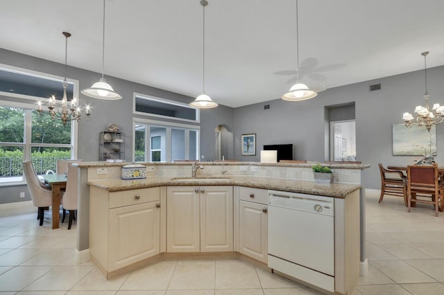 kitchen featuring a sink, light stone counters, light tile patterned floors, and dishwasher