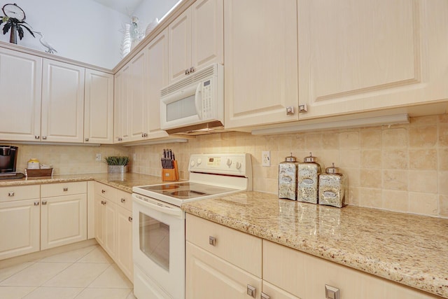 kitchen with light stone counters, tasteful backsplash, and white appliances