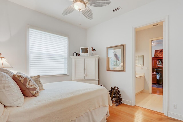 bedroom featuring baseboards, ensuite bathroom, light wood-type flooring, and visible vents