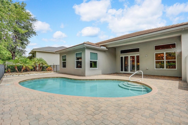 outdoor pool featuring a patio area and french doors