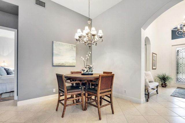 dining space featuring an inviting chandelier, visible vents, baseboards, and arched walkways