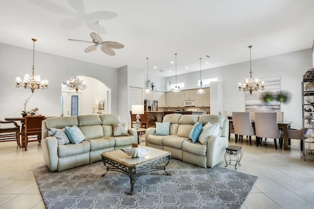 living area featuring ceiling fan with notable chandelier, arched walkways, light tile patterned floors, and recessed lighting