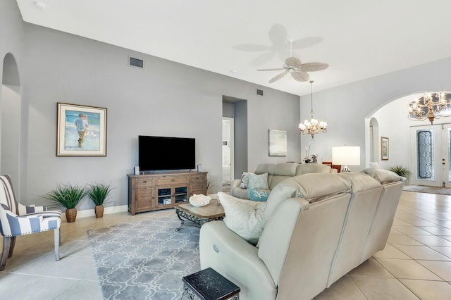 living room featuring arched walkways, light tile patterned floors, visible vents, and ceiling fan with notable chandelier
