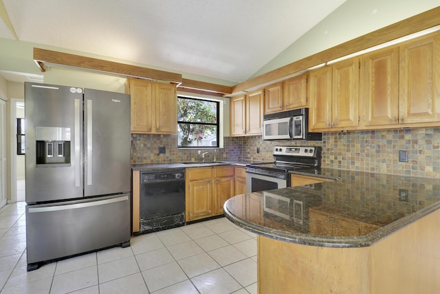 kitchen with light tile patterned flooring, a sink, backsplash, vaulted ceiling, and stainless steel appliances